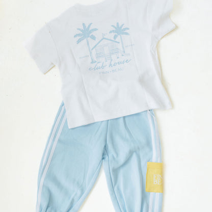 White t-shirt with palm tree design and light blue pants on a white background