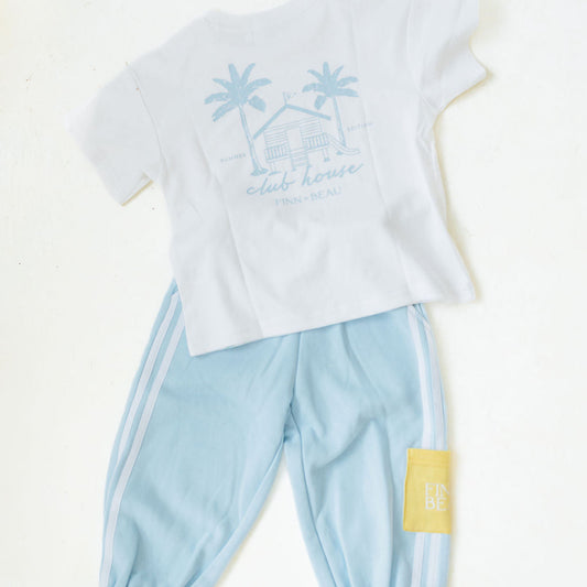White t-shirt with palm tree design and light blue pants on a white background