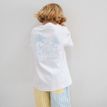 Person wearing a white shirt with a blue graphic and colorful shorts on a plain background